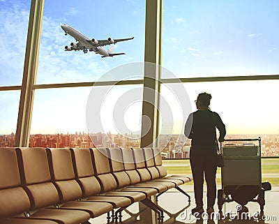 Single woman sitting in airport terminal and passenger plane fly Stock Photo