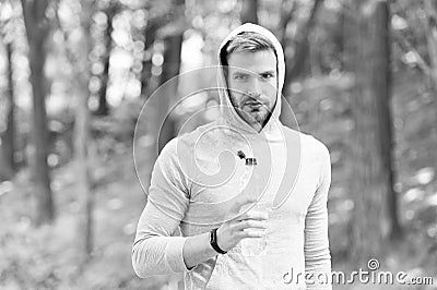 Sip of freshness after great workout. Man athletic appearance holds water bottle. Athlete drink water after training in Stock Photo