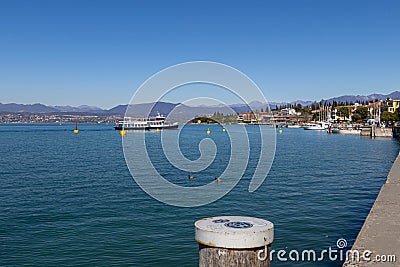 Sirmione, Lake Garda, Italy - 28 March 2023 Ferry arrives at port and harbour of Sirmione Stock Photo