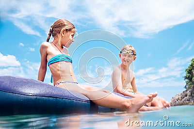 Sister and brother, have fun when swim on inflatable mattress in the sea. Careless childhood time Stock Photo