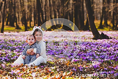 Sister and brother sitting in the middle of crocus valley Stock Photo