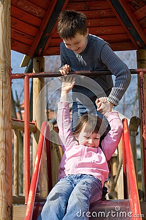 Sister And Brother On Slide Stock Photo