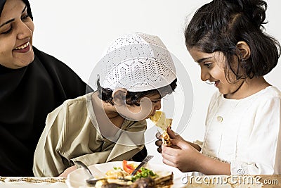 Sister feeing brother in a family dinner Stock Photo