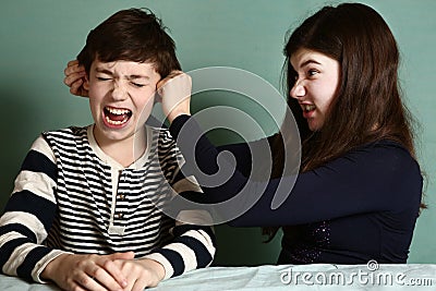 Sister pull brother ear as a loss in argument Stock Photo