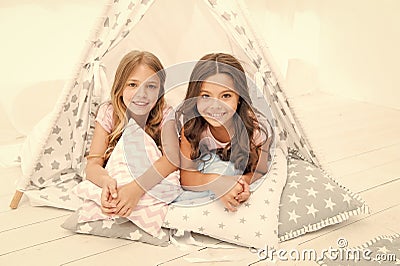 Sisters or best friends spend time together lay in tipi house. Girls having fun tipi house. Girlish leisure. Sisters Stock Photo