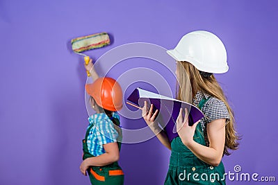 Sisters happy renovating home. Home improvement activities. Renovation team. Kids girls planning renovation. Repaint Stock Photo