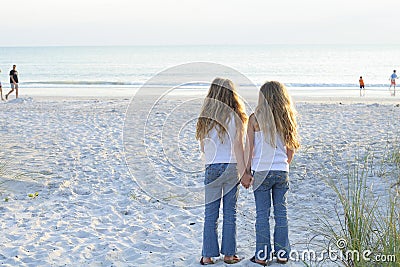 Sisters holding hands on the beach Stock Photo