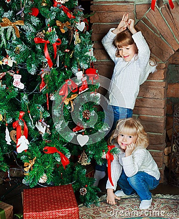 Sisters at home with Christmas tree Stock Photo