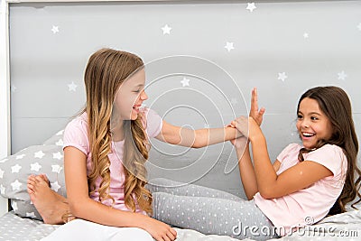 Sisters leisure. Girls in cute pajamas spend time together in bedroom. Sisters communicate while relax in bedroom Stock Photo