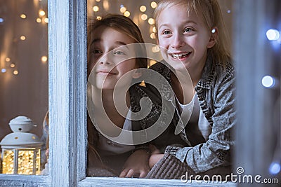 Sisters looking through the window Stock Photo