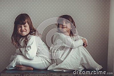 Sisters in nightgowns play on old trunk Stock Photo