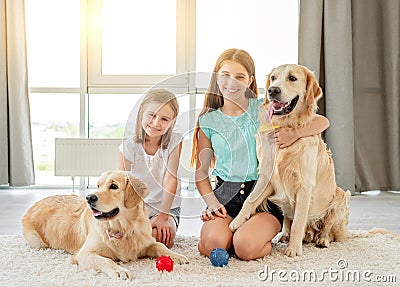 Sisters playing with golden retrievers Stock Photo