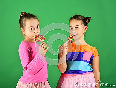 Sisters with round, long shaped lollipops. Girls with happy faces Stock Photo