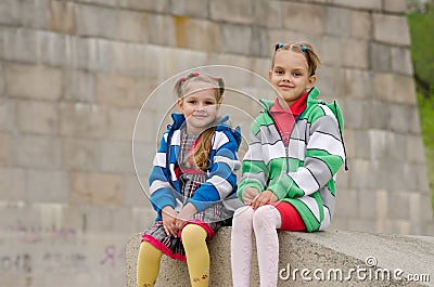 Sisters sitting on a granite ramp Stock Photo