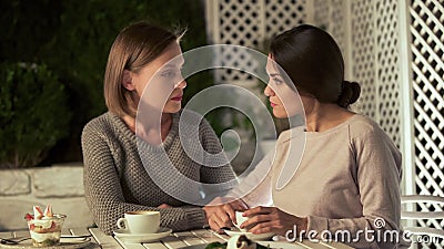 Sisters talking about life, sitting on terrace together, problem discussion Stock Photo