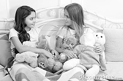 Sisters unite. Little sisters play toys in bed. Small sisters relax before nap time. Adorable sisters or friends in Stock Photo