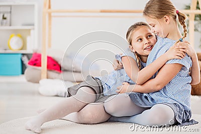 Sisters wearing blue shirts hugging Stock Photo