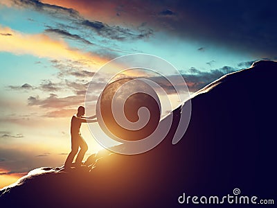 Sisyphus metaphor. Man rolling huge concrete ball up hill. Stock Photo