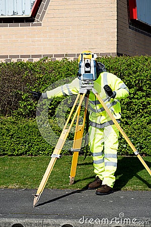 Site engineer doing road survey using modern robotic total station EDM before beginning of construction works and setting Stock Photo
