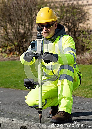 Site engineer doing road survey using modern robotic total station EDM before beginning of construction works and setting Stock Photo