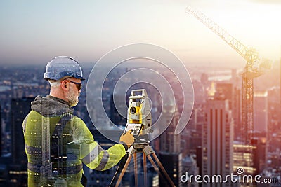 Site engineer surveyor with an electronic theodolite in front of a big modern city with electronic noise of artificial Stock Photo