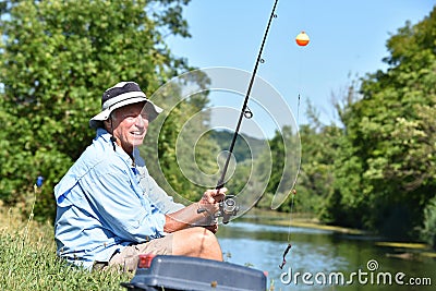 Sitting Old Retiree Male Fisherman With Fishing Rod Outdoors Stock Photo