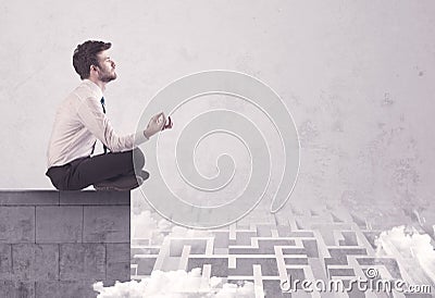 Sitting salesman on rooftop solving maze Stock Photo