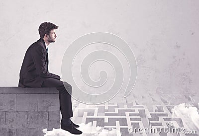 Sitting salesman on rooftop solving maze Stock Photo