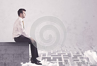 Sitting salesman on rooftop solving maze Stock Photo