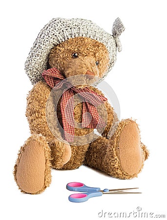 Sitting teddy bear with hat and scissors Stock Photo