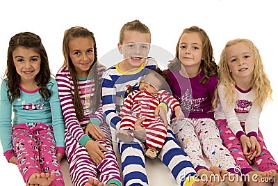 Six beautiful children wearing their winter pajamas sitting Stock Photo
