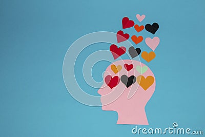 six colorful paper hearts in a pink paper head, more hearts floating above the head come out of it Stock Photo