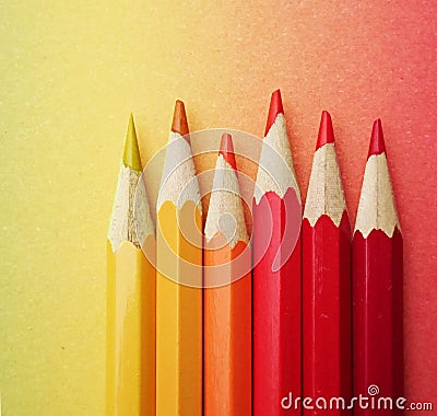 Six colorful pens arranged in the colors yellow and red on colorful paper in the course of the rainbow Stock Photo