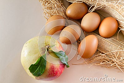 Six eggs and one pomegrenate on sackcloth burlap and white bac Stock Photo