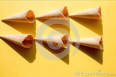 Six empty waffle cups for ice cream on a yellow background in bright sunlight and crisp, hard shadows Stock Photo