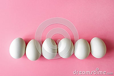 Six empty white chicken eggs beside on a pale pink background Stock Photo