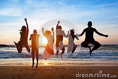 Six people jumping on beach at sunset. Stock Photo