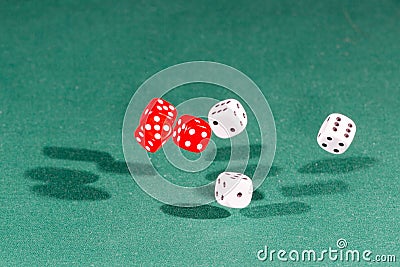 Six red and white dices falling on a green table Stock Photo