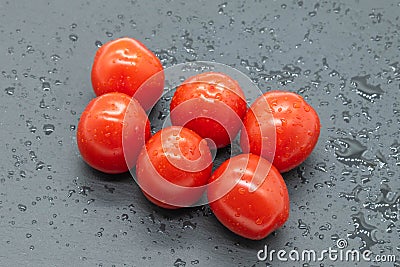 Six small tomatoes just washed and ready to eat. Stock Photo
