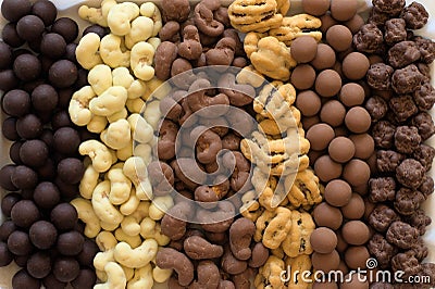 Six types of chocolate covered nuts in vertical rows Stock Photo