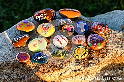 Sixteen painted rocks on a boulder in afternoon sun Stock Photo