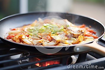 sizzling kimchi pancake cooking on gas stove Stock Photo