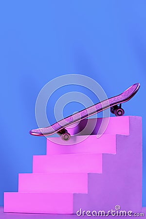 Skate in pink on the stairs, as a symbol of extreme sports, skateboarding, parkour, roller skates on a blue background Stock Photo