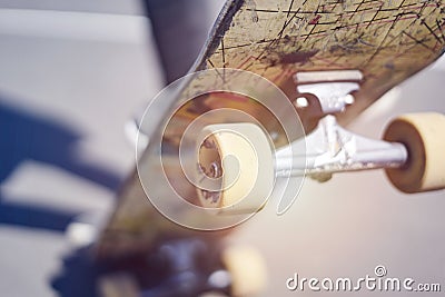 Skateboarder doing a trick in a skate park, close-up old skateboard. Stock Photo