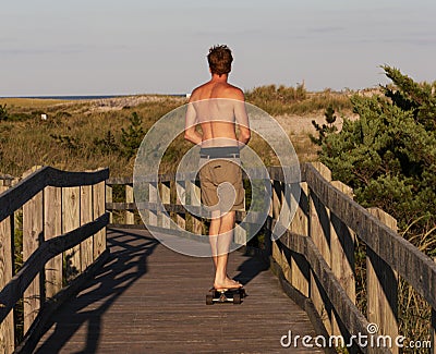 Skateboarder on Fire Island Lighthouse boardwalk Editorial Stock Photo