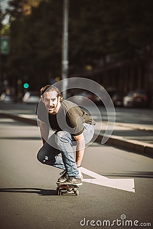 Skateboarder ride a skateboard slope through the city street Stock Photo