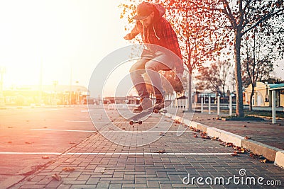 Skateboarding. A man does an Ollie stunt on a skateboard. Jump in the air. Street on the background. Sunlight Stock Photo