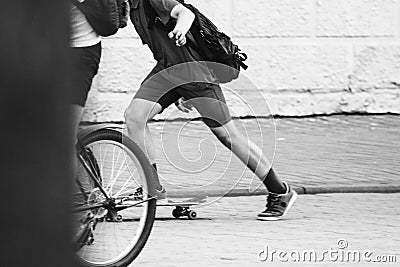 Teen in shorts rides a skateboard. Black and white Stock Photo