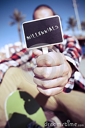 Skater shows a signboard with the text millennials Stock Photo