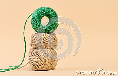 Skein of green and brown thread on a beige background Stock Photo